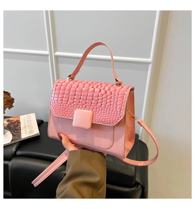 Détail du sac bandoulière rose avec rabat gaufré crocodile et boucle carrée élégante