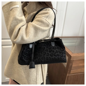 Détail d'un sac cabas chic à imprimé léopard en faux daim noir avec breloques élégantes