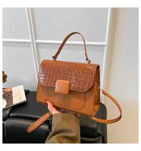 Détail du sac bandoulière orange tendance avec texture crocodile et boucle élégante