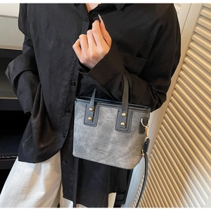 Close-up of vintage contrast tote bag with premium leather texture and metallic rivets