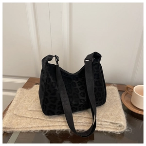 Detail of black leopard print crossbody bag with velvet texture and adjustable strap