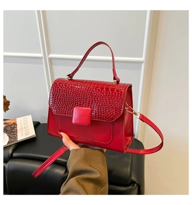 Détail du sac à main rouge en cuir croco avec boucle carrée et bandoulière amovible