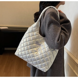 Close-up of silver quilted tote bag featuring padded texture and Fashion Instinct label