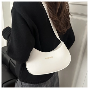 Chic off-white half-moon shoulder bag with gold lettering shown on a model