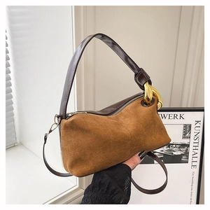 Détail du sac à bandoulière en daim avec chaîne dorée décorative sur la bandoulière