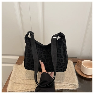 Close-up of small square crossbody bag with leopard print and adjustable shoulder strap