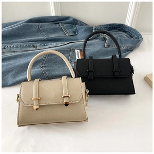 Detail of beige and black mini cross-body bags with cross-grain texture on denim jacket