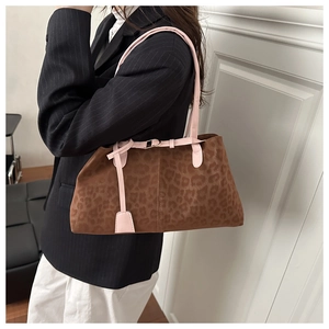 Close-up of leopard print bag with pink leather strap detailing and soft suede texture