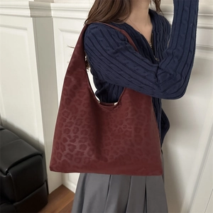 Fashionable burgundy leopard print hobo tote bag for women in a stylish casual pose