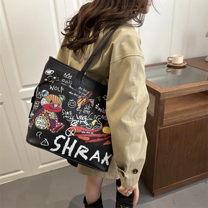 Τσάντα tote με τύπωμα γκράφιτι street style φορεμένη από μοντέλο με καμπαρντίνα