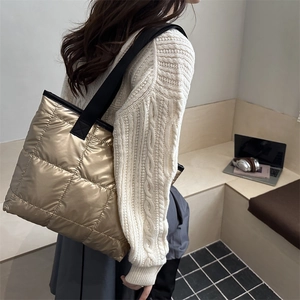 Champagne gold quilted tote bag with black straps in a minimalist urban office setting