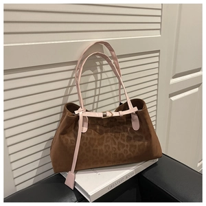 Détail du sac cabas léopard avec une bandoulière en cuir rose et une boucle en métal