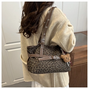 Detail of leopard print shoulder bag with teddy bear charm and brown leather trim