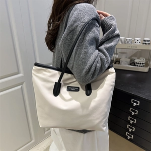 Minimalist cream and black contrast tote bag for women with large capacity shown on model