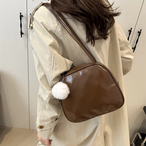 Polished dark brown leather shoulder bag for women with a cute white plush pendant