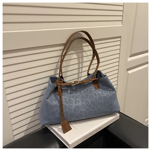 Détail du cabas léopard bleu clair avec bandoulière marron et boucle métallique