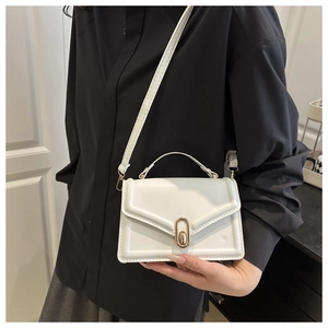 Detail einer weißen Vintage-Tasche mit elegantem goldenen Oval-Drehverschluss für Damen