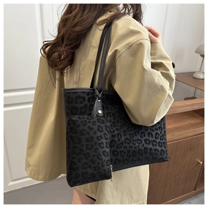 Detail of large leopard print tote bag with matching inner pouch for women on shoulder