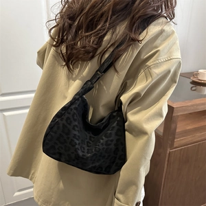 Minimalist black leopard print crossbody bag with adjustable wide strap and crescent shape