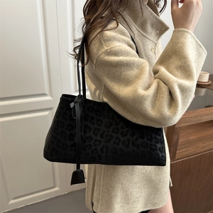 Sac fourre-tout chic léopard noir en suédine porté par un mannequin femme