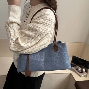Fashionable blue leopard print tote bag with brown straps styled for winter fashion
