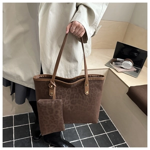Detail of leopard print tote bag with matching pouch and brown leather trim accents