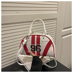 Détail du sac bowling blanc avec rayures rouges et broderie 96 tenu à la main