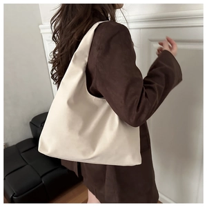 Minimalist beige oversized hobo tote bag shown from a back-view perspective on a model