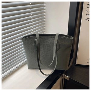 Detail of grey-green suede tote bag with leopard print and thin shoulder straps