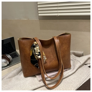Détail du grand sac cabas marron avec surpiqûres blanches et foulard décoratif élégant
