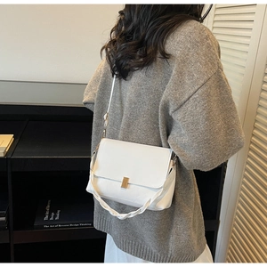 Detailed back view of a white flap crossbody bag with woven handle and gold clasp