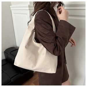 Minimalist beige hobo bag worn by model in dark brown blazer for stylish daily commute