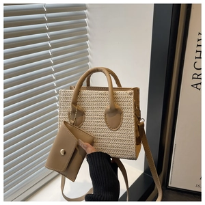 Détail du sac carré en paille tressée avec une mini pochette amovible et anses en cuir PU