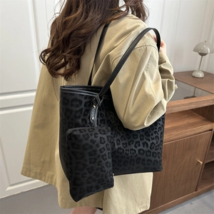 Leopard print tote bag with small pouch shown on shoulder in a minimalist indoor setting