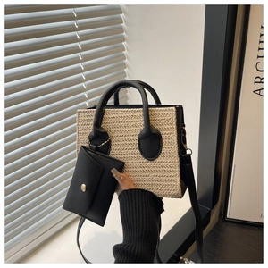 Détail du sac à main en paille tressée avec garniture en cuir noir et petite pochette