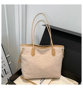 Detailansicht der cremefarbenen Plüsch-Tasche mit Lederbesatz in einer schlichten Geschenkbox