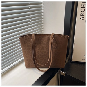 Detailed view of large leopard print suede tote bag with textured finish and slim straps