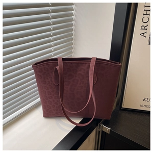 Detail showing burgundy leopard print texture on a large capacity tote bag
