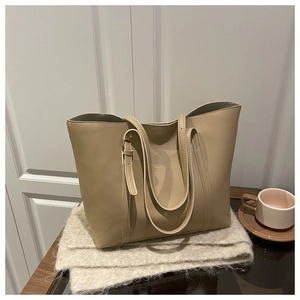 Beige oversized tote bag on a knitted scarf with coffee, showcasing its premium leather texture