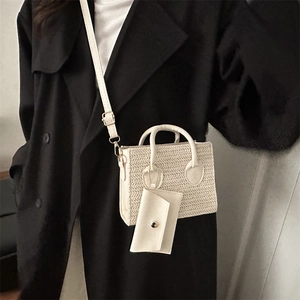 White woven crossbody bag with mini pouch shown on black coat for sleek contrast