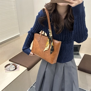 Sac fourre-tout vintage marron caramel avec foulard imprimé porté par le modèle