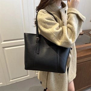 Minimalist large black tote bag in matte leather with gold adjustable shoulder straps