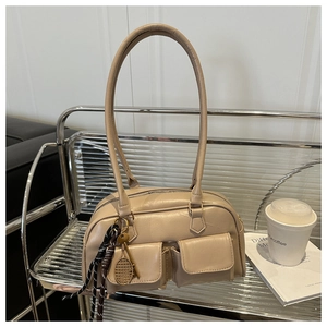 Dettaglio borsa a spalla in pelle beige opaca con ciondolo a racchetta da tennis