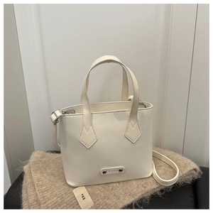 Dettaglio borsa a secchiello in ecopelle color crema con targhetta fashion su sciarpa