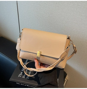 Close-up of beige crossbody bag showing fine faux leather texture and gold metal buckle