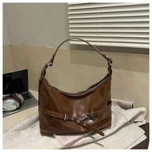 Dettaglio della borsa hobo marrone scuro lucida con fibbia decorativa e parti metalliche