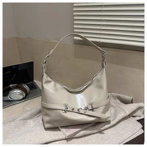 Dettaglio di una borsa hobo in pelle color crema con fibbia in metallo e tracolla