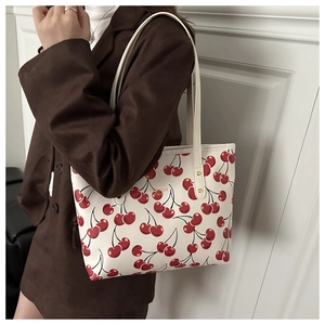 Détail d'un sac cabas blanc avec motifs cerises rouges et texte doré Fashion Bags