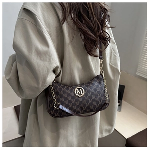 Detail der Vintage-Monogramm-Unterarmtasche mit goldnem Logo und Kettenriemen