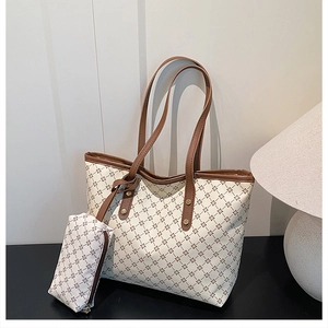 Detail of minimalist tote bag set featuring clover pattern and gold rivet accents